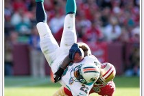 49er strong safety Donte Whitner slams down Dolphin running back Reggie Bush