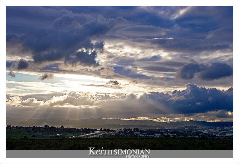 Rays of sunlight stream through the coming storm clouds onto Highway 4 in Pleasant Hill, California
