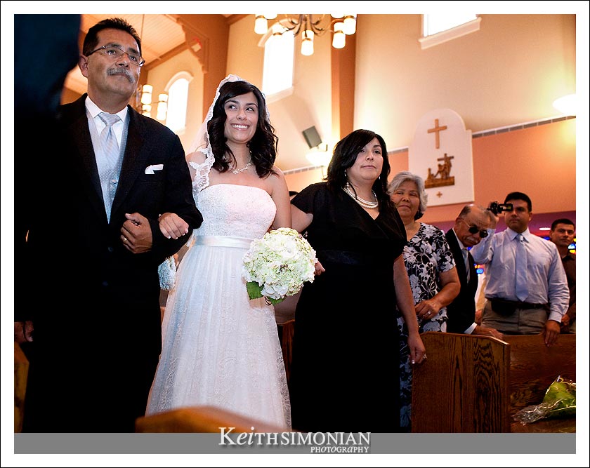 Bridgett walks up the aisle with her mother and father