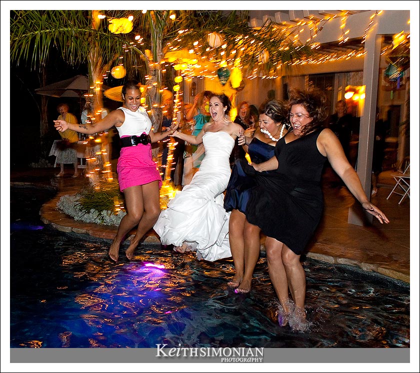 The bride, a bridesmaid, and a couple friends trash their dresses by jumping into the swimming pool