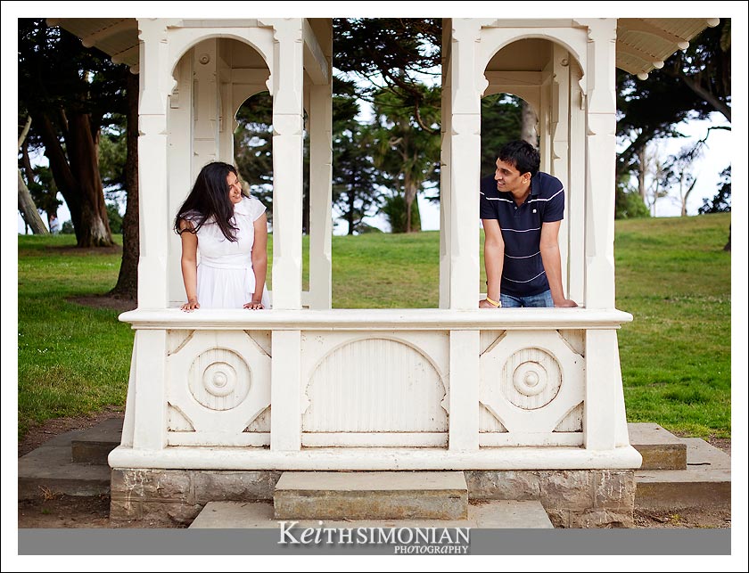 Couple pose in park structure during engagement photos