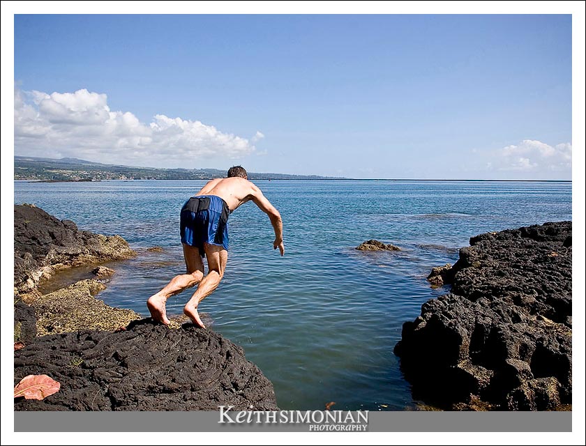 A swimmer dives into the ocean from the lava rock the surrounds it in the city of Hilo on the Big Island of Hawaii.