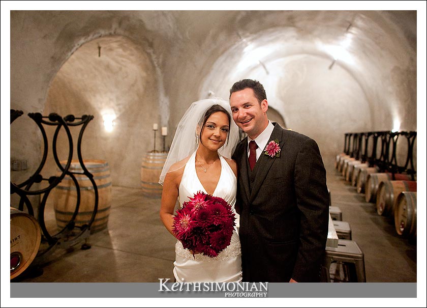 The bride and groom take a photo in the cave at the Caldwell Vineyard - Napa Valley California