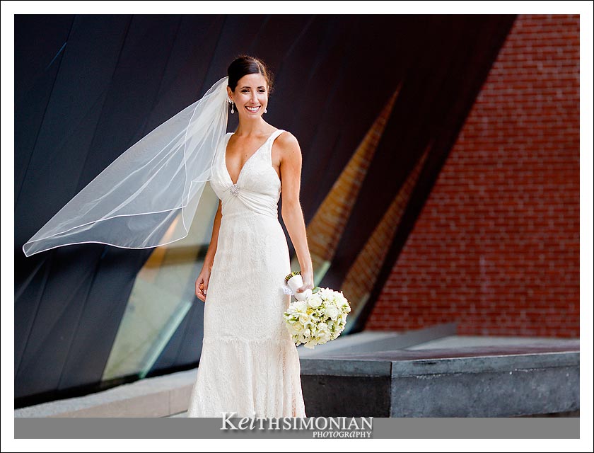 Photo of Bride with bouquet in front of brick building
