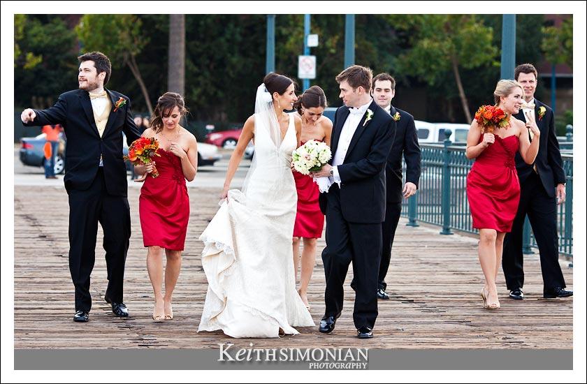 The bridal party walks along the San Francisco pier