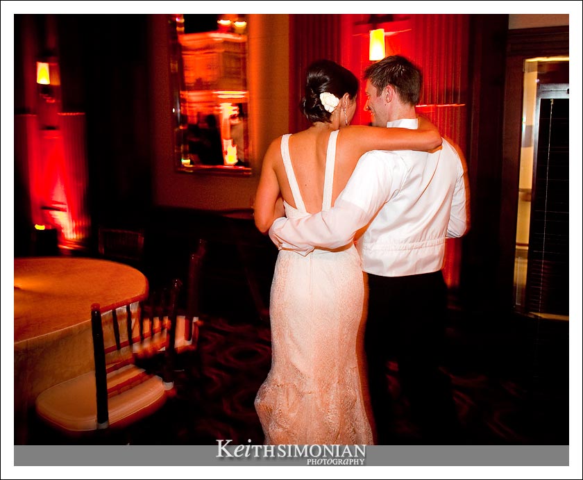 A slow shutter speed in this photo causes the slight blur and the bride and groom walk in the Julia Morgan ballroom in San Francisco