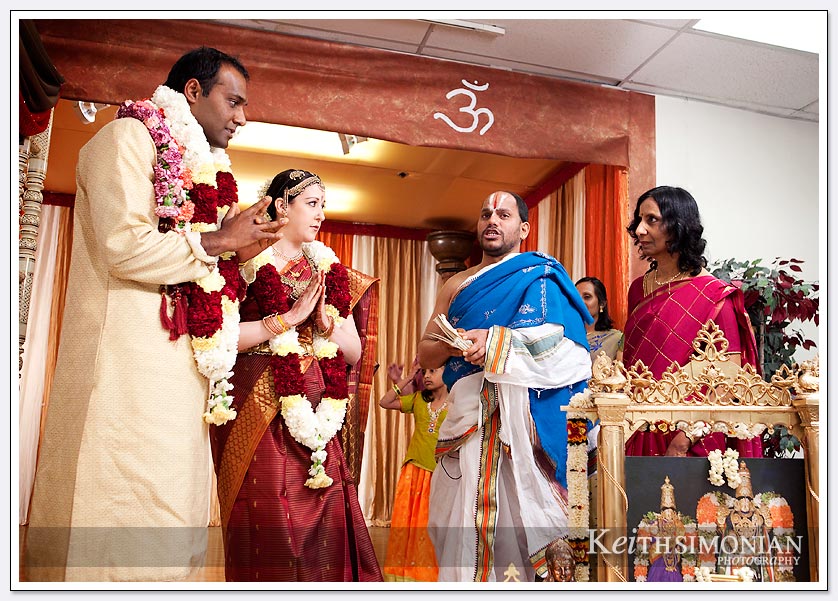 The couple wearing their garlands listen to the priest during the South Indian Hindu wedding ceremony at the Shiva-Vishnu Temple in Livermore, California