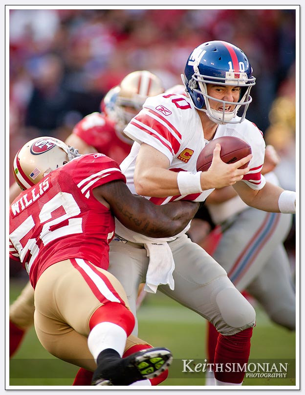 QB Eli Manning is sacked by Patrick Willis