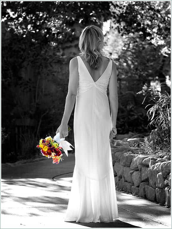Black and white photo with limited color showing bride holding bouquet