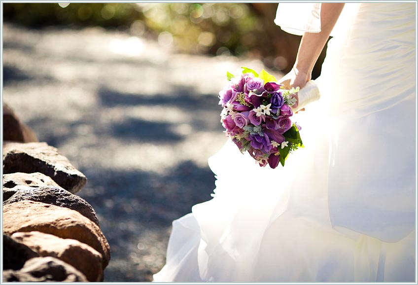 Bride's dress and her holding a bouquet of purple flowers in the Napa Valley