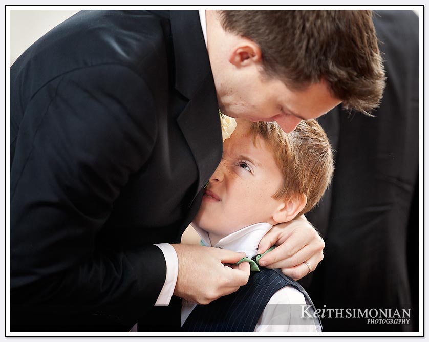 Dad puts on the finishing touches of ring bearer tie