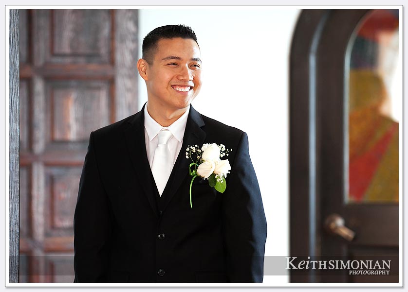 The groom is all smiles as he greats guests at his wedding ceremony