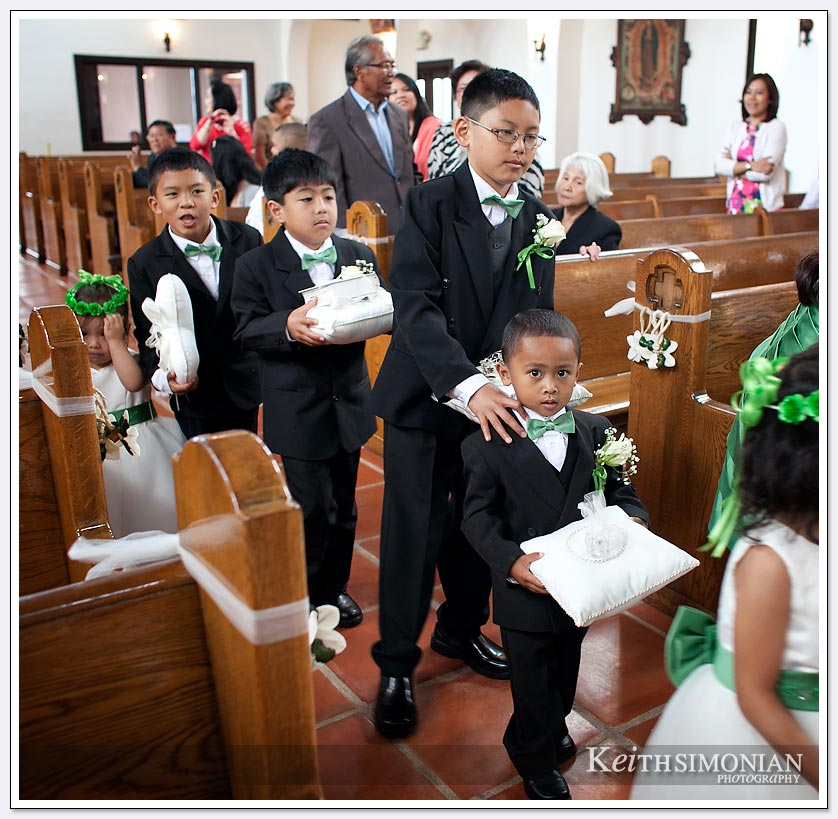 The ring bearer and helpers along with flower girls cause a traffic jam walking up the aisle