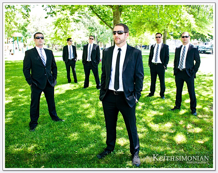 The groom and groomsmen pose for photo in park setting in the city of Sonoma.