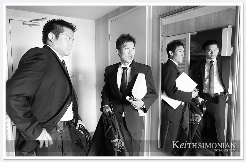 Black and white photo showing the reflections of groomsmen