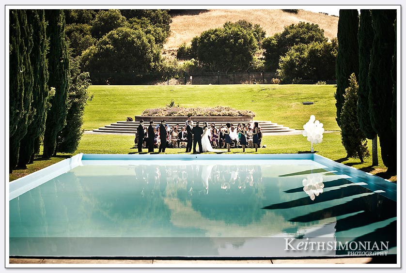 The wedding ceremony as seen across the reflection pool at Pulgas Water temple