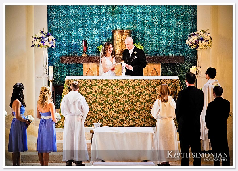 The bride and groom light the unity candle during a wedding at Our Lady Queen of Angels in Newport Beach