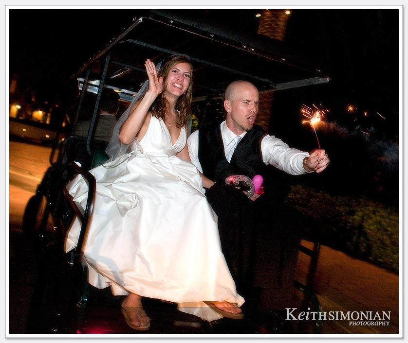 The bride and groom ride off in a golf cart after their Platinum wedding reception at the Pelican Hill Resort in the Mar Vista Ballroom