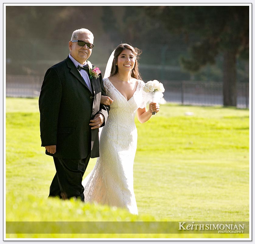 The bride and her father walk from the golf course to the ceremony at The Lakes at El Segundo Wedding