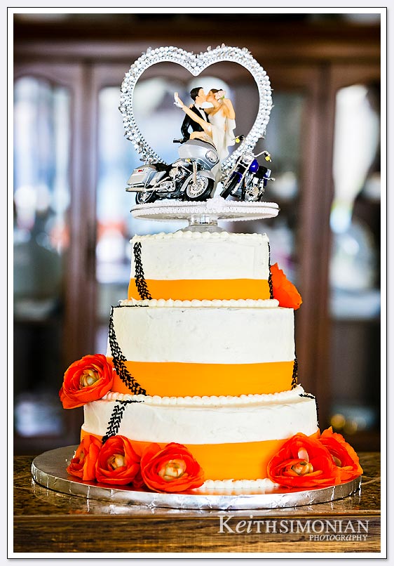 The orange and white wedding cake featured motorcycles as both the bride and groom ride.