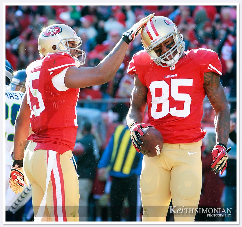 	Dec 8, 2013; San Francisco, CA:  San Francisco 49ers tight end Vernon Davis (#85) is patted on the helmut by Michael Crabtree #15 after catching a touchdown pass against the Seattle Seahawks in the second quarter at Candlestick Park.