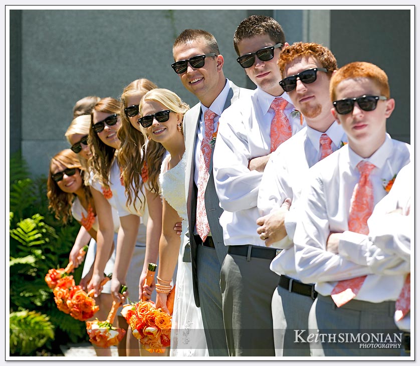 The entire wedding party poses for photo wearing sunglasses by the Oakland LDS temple