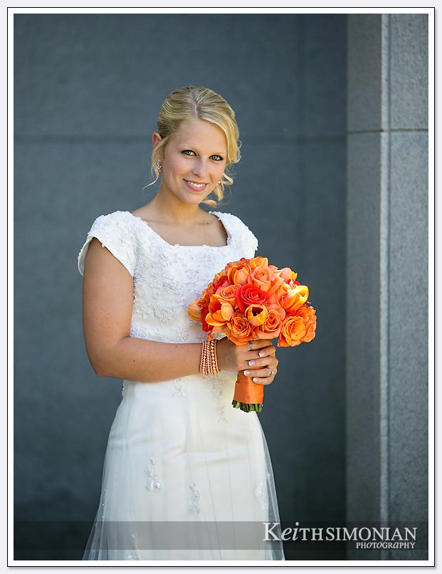 The bride poses outside the Oakland LDS temple with her bouquet