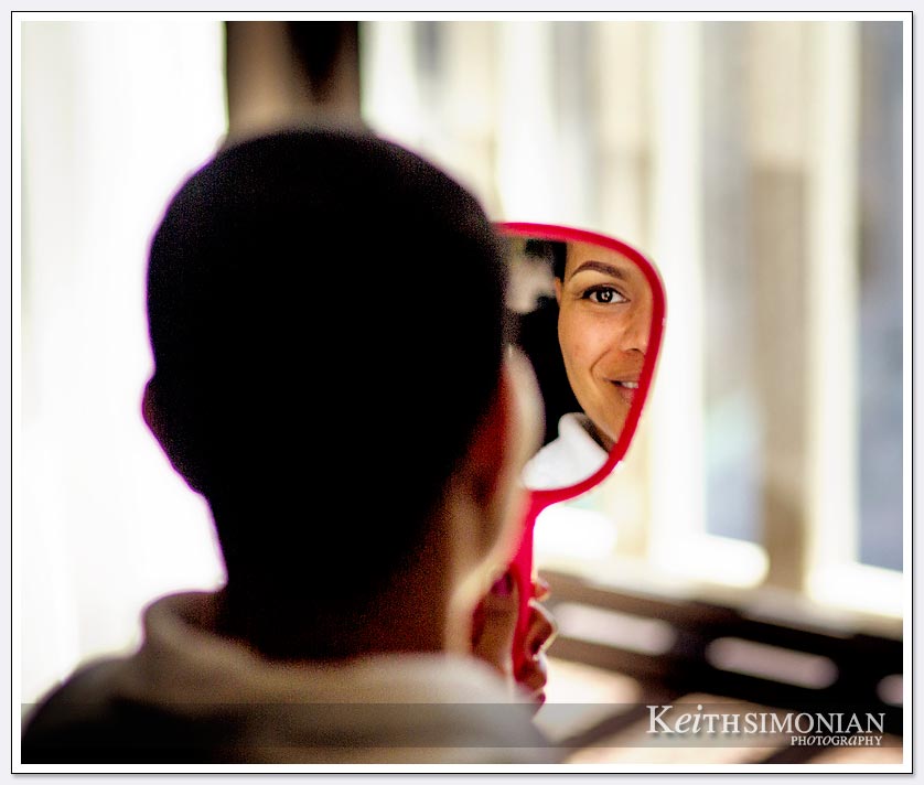 Bride views herself in mirror while getting ready in Le Meridien Hotel in San Francisco