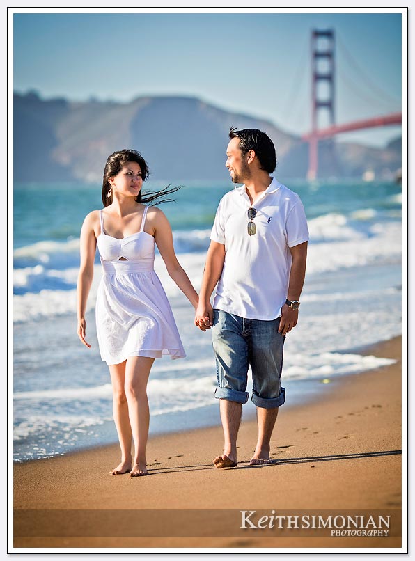 Walking along Baker beach with the Golden Gate bridge as the background - San-Francisco-Engagement-Photos
