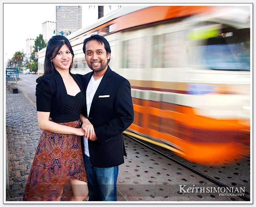 The vintage trolley car speeds by as the couple poses for the image - San-Francisco-Engagement-Photos