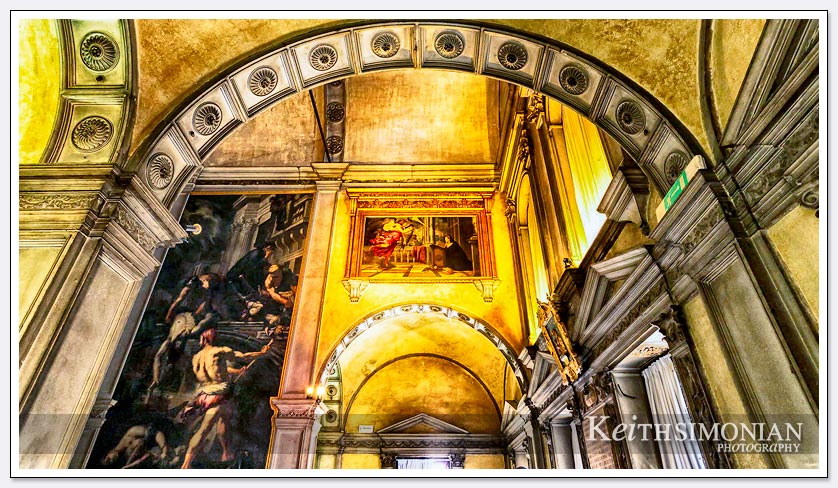 The yellow light shinning on the painting creates a dramatic canvas for the viewer in this Venice, Italy church.