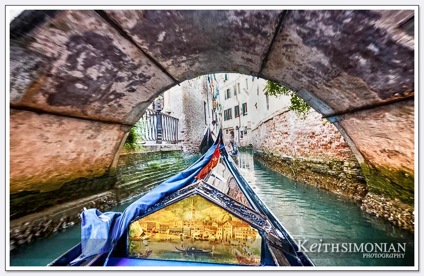 Gondola passes under one of the many bridges in Venice, Italy