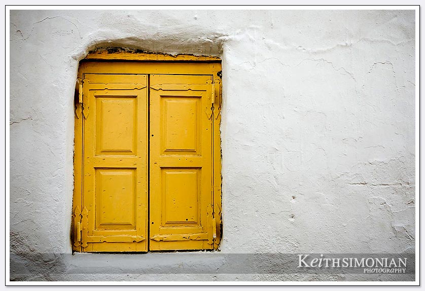 Yellow door and white building in the old town of Mykonos, Greece