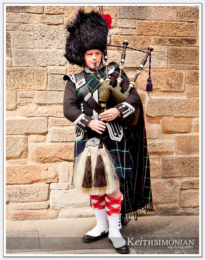 Man in kilt playing the bagpipes streets side in Edinburgh Scotland