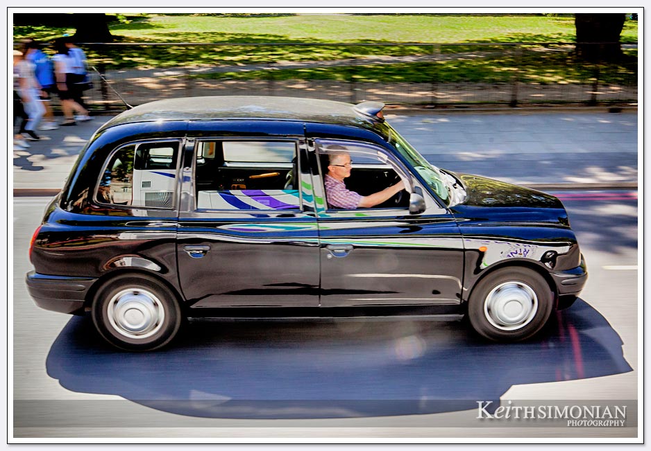 Distinctive black London cab zoom by