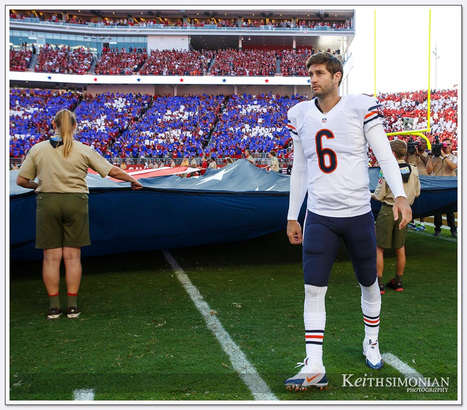 Chicago Bears quarterback Jay Cutler helps hold the American flag during the playing of the national anthem. 
