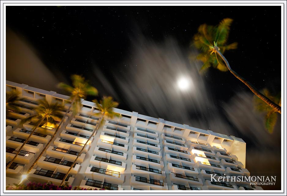 A perfectly time cloud covers the moon during a long exposure photo of the Maui Resort Hotel - Maui Hawaii