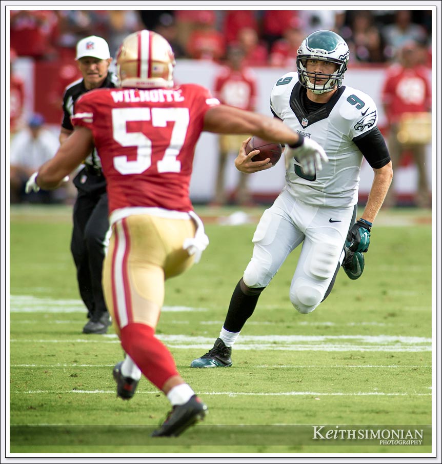 Eagles quarterback Nick Foles scrambles down field as San Francisco 49er linebacker #57 Michael Wilhoite pursues him during this 2014 game at Levi's Stadium in Santa Clara, California
