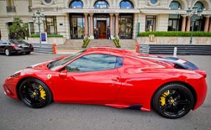 Fast cars in Monte Carlo - a Red Ferrari in front of the Hotel de Paris