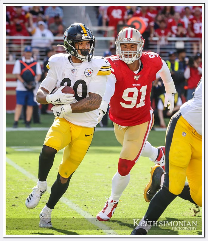 Pittsburgh Steeler running back #30 James Conner tries to elude San Francisco 49er defensive end #91 Arik Armstead at Levi's Stadium on September 22, 2019.