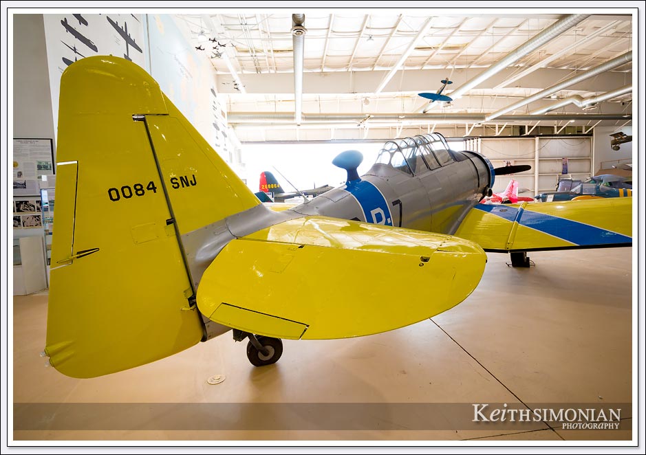A yellow tailed North American AT-6/SNJ Texan sits in the Pacific hanger of the Palm Springs air museum. 