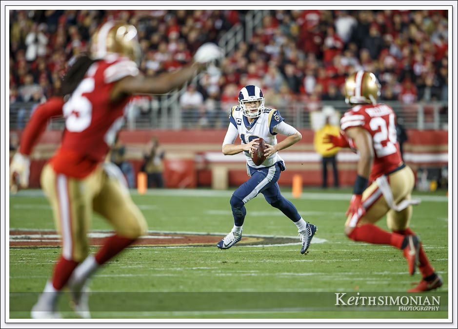Los Angeles Ram quarterback #16 Jarad Goff rolls out to avoid a sack from the San Francisco 49ers defense.