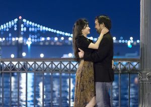 Nighttime engagement photos with the Bay Bridge as backdrop
