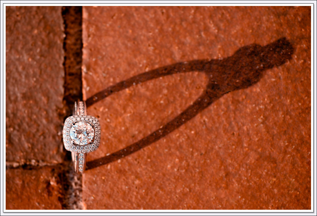 The engagement ring casts a shadow over the red bricks