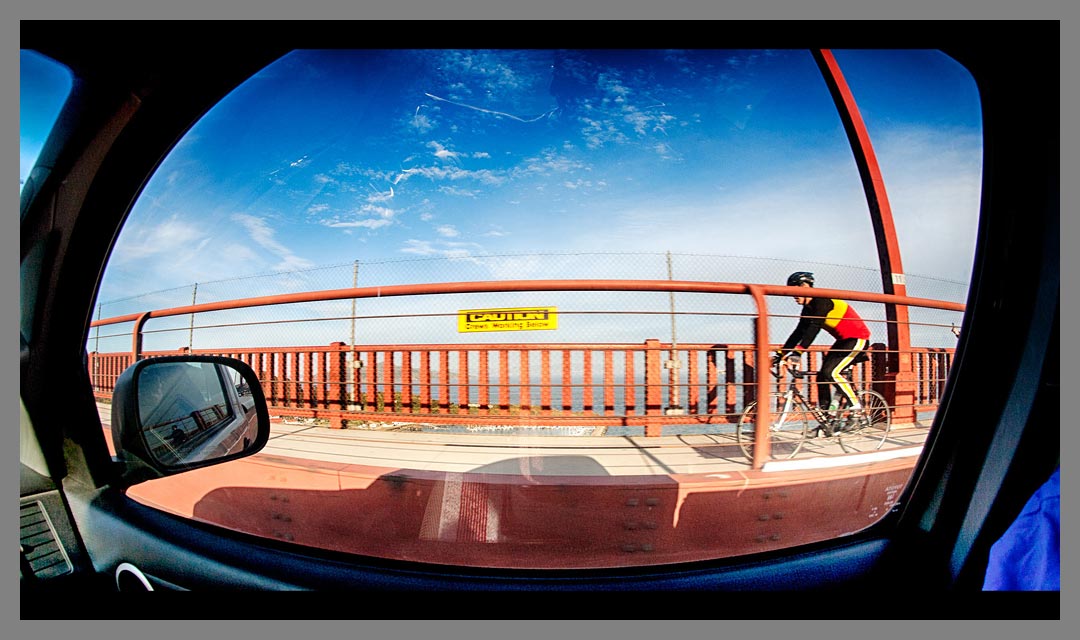 Bicycle rider on the Golden Gate bridge photographed with fisheye lens and then HDR processed. 