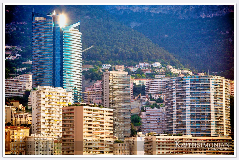 An early morning arrival in Monaco displays the low Sun shining off the glass of a high rise. 