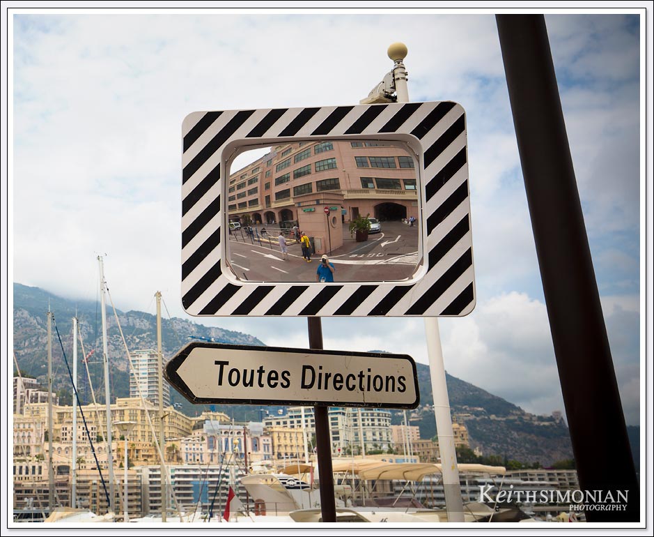 A mirror above the Toutes Directions sign helps oncoming traffic avoid hitting each other in streets of Monaco. 