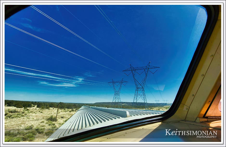 View from Grand Canyon train ride dome car as it passes under high power electrical transmission lines - Arizona