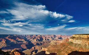 Clouds fill the blue sky as the Sun sets over the Grand Canyon