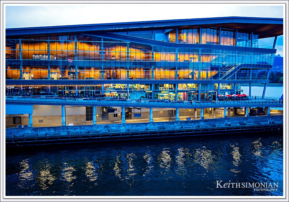 The lights of the Vancouver Convention center cast a reflection on the water below. 